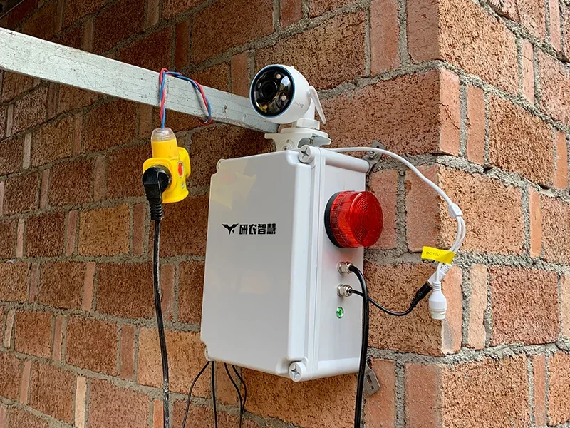 Camera and alarm light unit on a pig barn wall